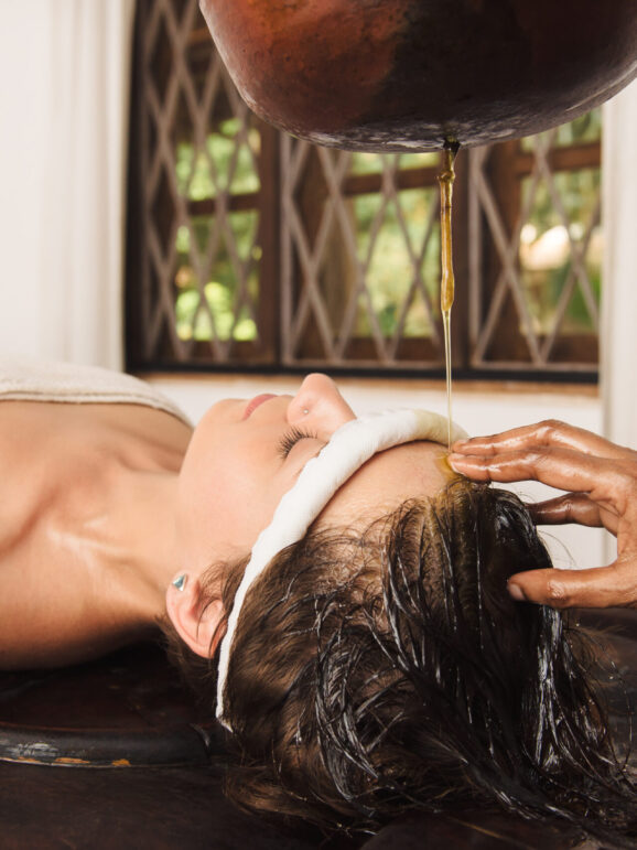 Caucasian woman having Ayurveda shirodhara treatment in India